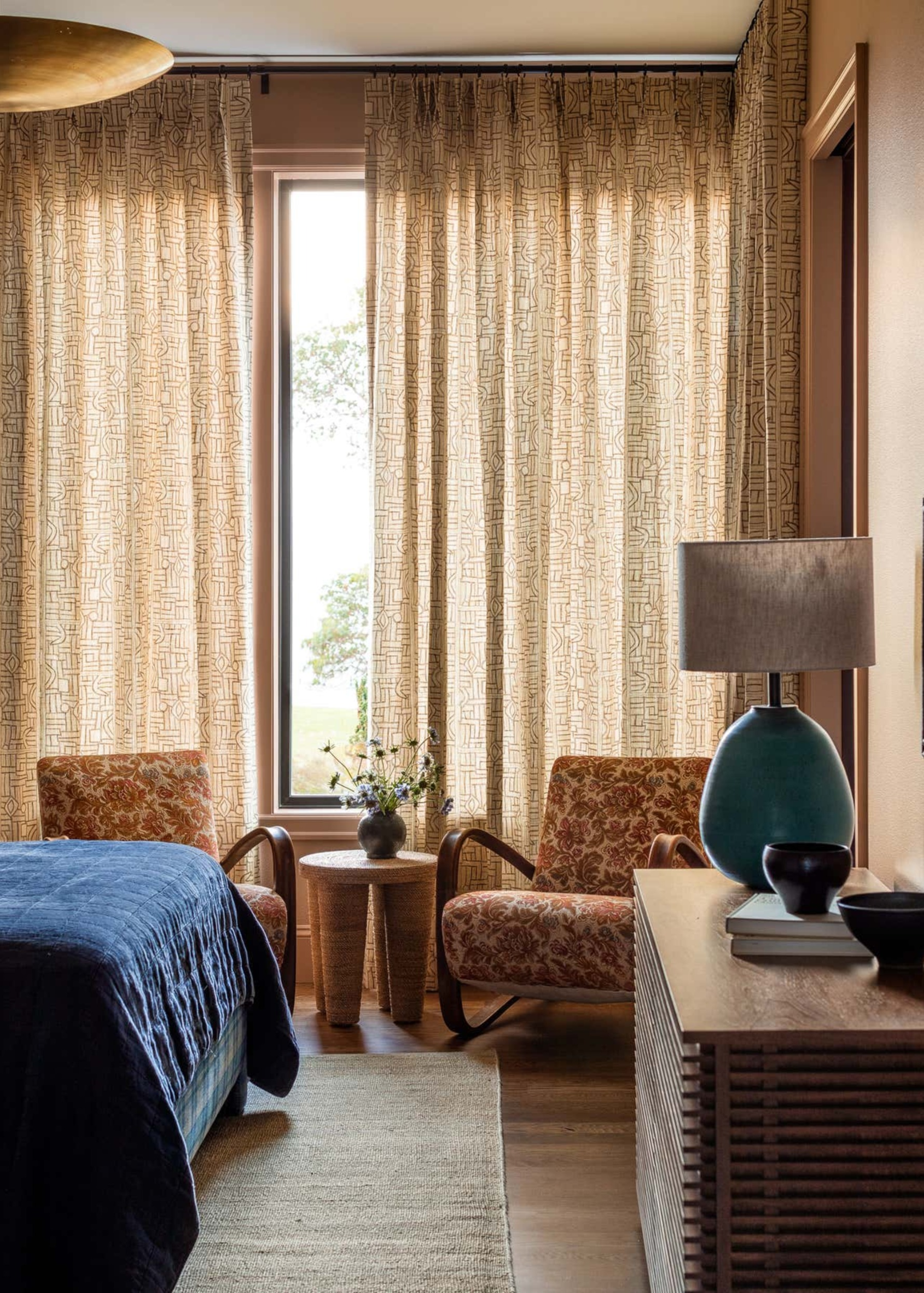 A bedroom with seating area next to the window