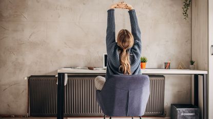Woman stretches at desk
