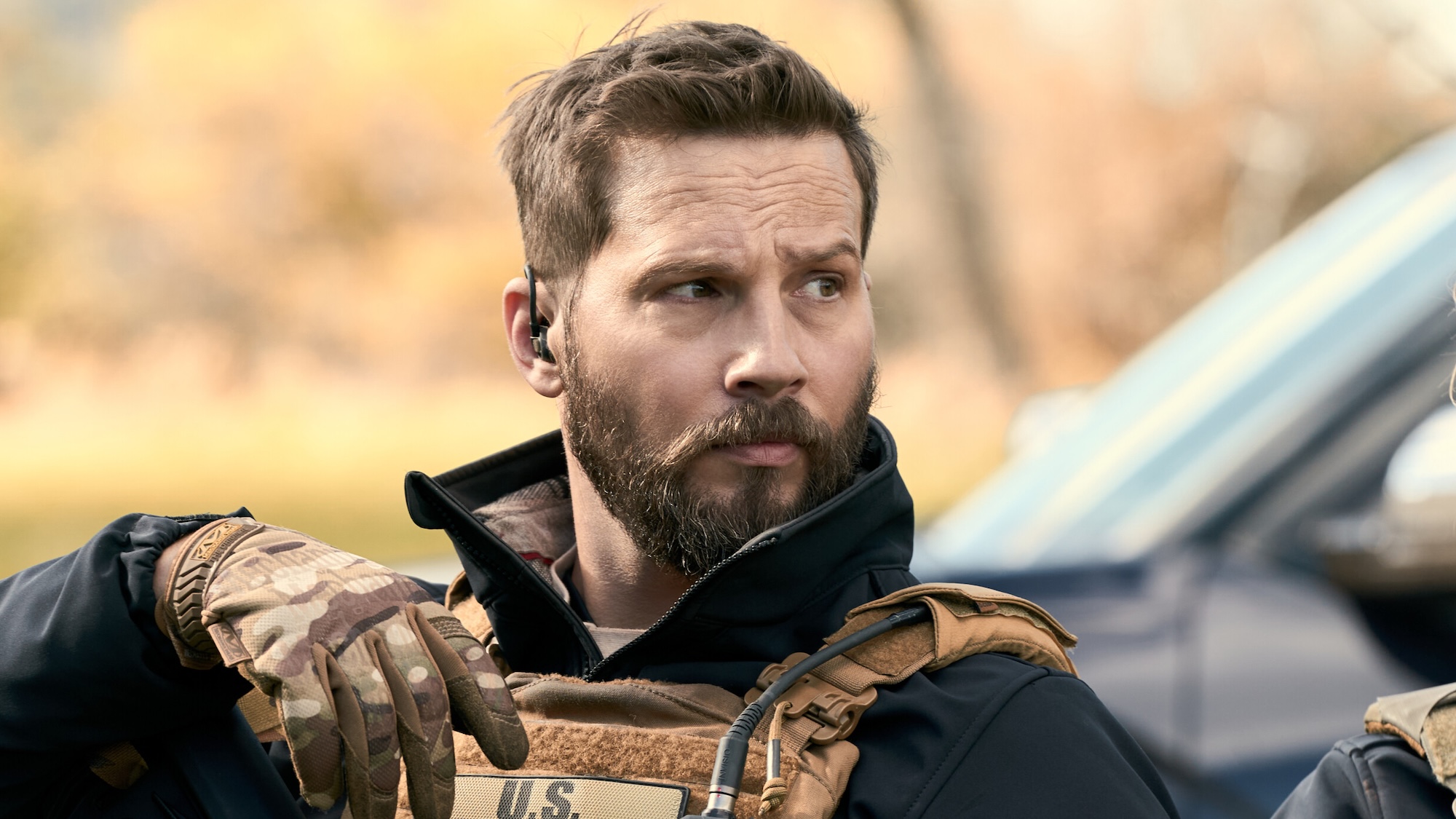 Logan Marshall-Green's Cal wearing US Marshals uniform and gloves looking to his left in Marshals Season 2