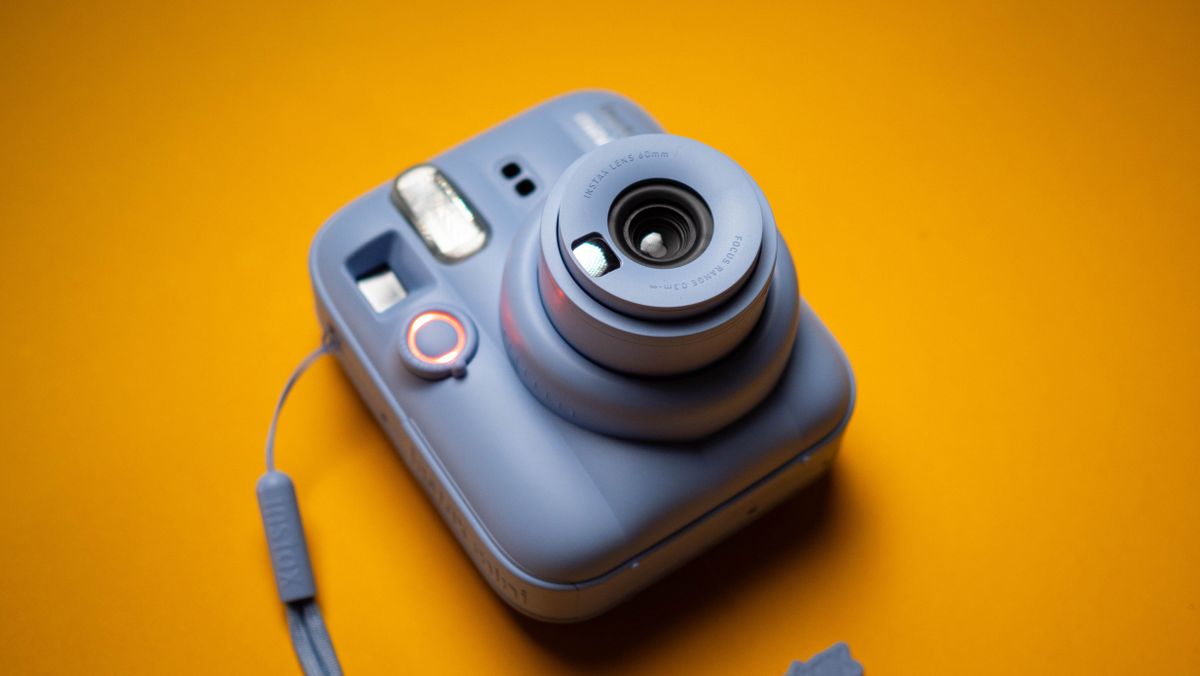 Fujifilm Instax Mini 13 instant camera against a yellow colored sheet