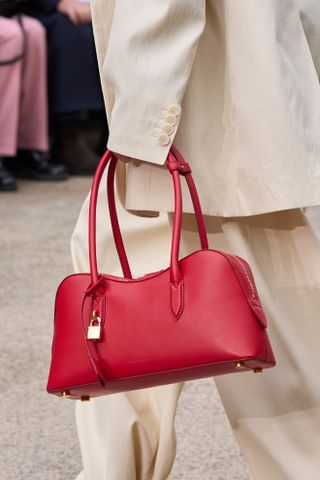 Model carries a red bowler bag on the Stella McCartney runway.