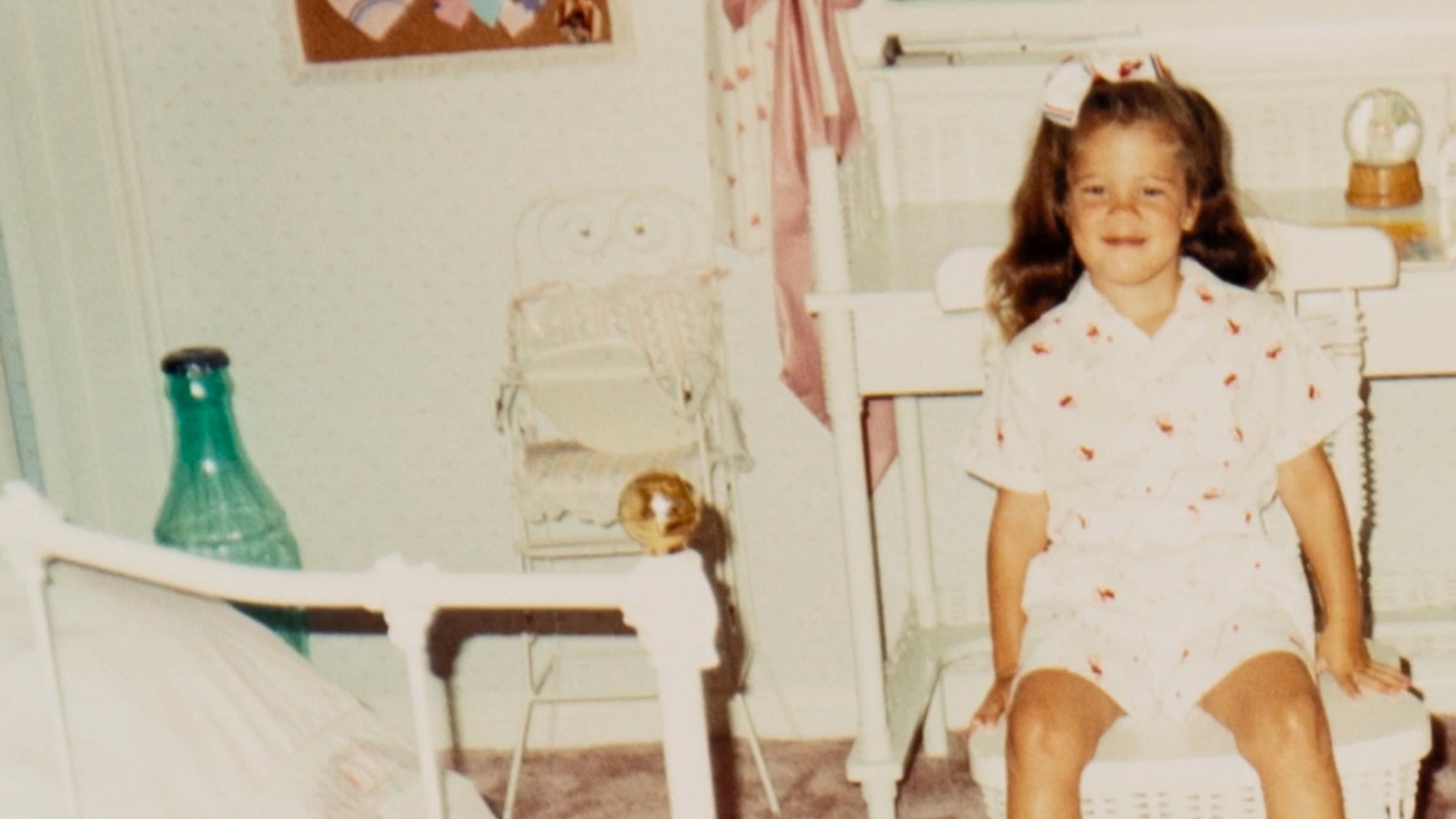 A childhood photo of Khloe Kardashian is shown on The Kardashians, with the Coke bottle bank she ended up giving Kim in the background.