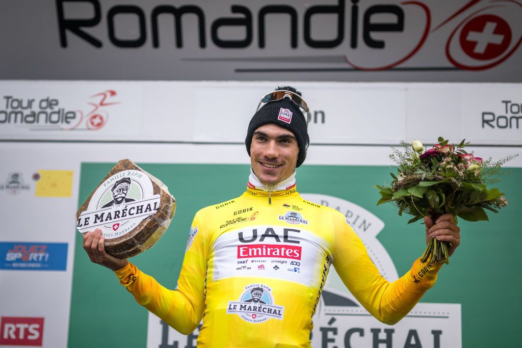UAE Team Emirates's Spanish rider Juan Ayuso celebrates on the podium with the overall leader's yellow jerseyafter the third stage of the Tour of Romandy UCI cycling World tour, a 15.5 km time trial starting and finishing in Oron, in Maracon, western Switzerland, on April 26, 2024. (Photo by Fabrice COFFRINI / AFP)