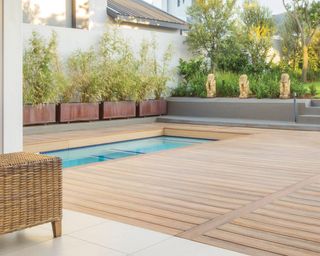 Eva-Last Himalayan cedar light brown composite apex ceck board in back garden with pool and ornamental feature decor