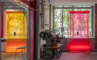 Design units with machinery on display and two digitally crafted coloured resins (yellow and red) placed by windows in a room