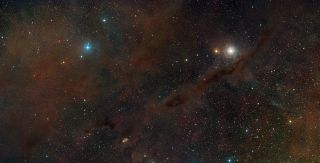 This image shows a wide-field view of part of the Taurus Molecular Cloud, about 450 light-years from Earth. Its relative closeness makes it an ideal place to study the formation of stars. Many dark clouds of obscuring dust are clearly visible against the background stars. Image released Feb. 15, 2012.