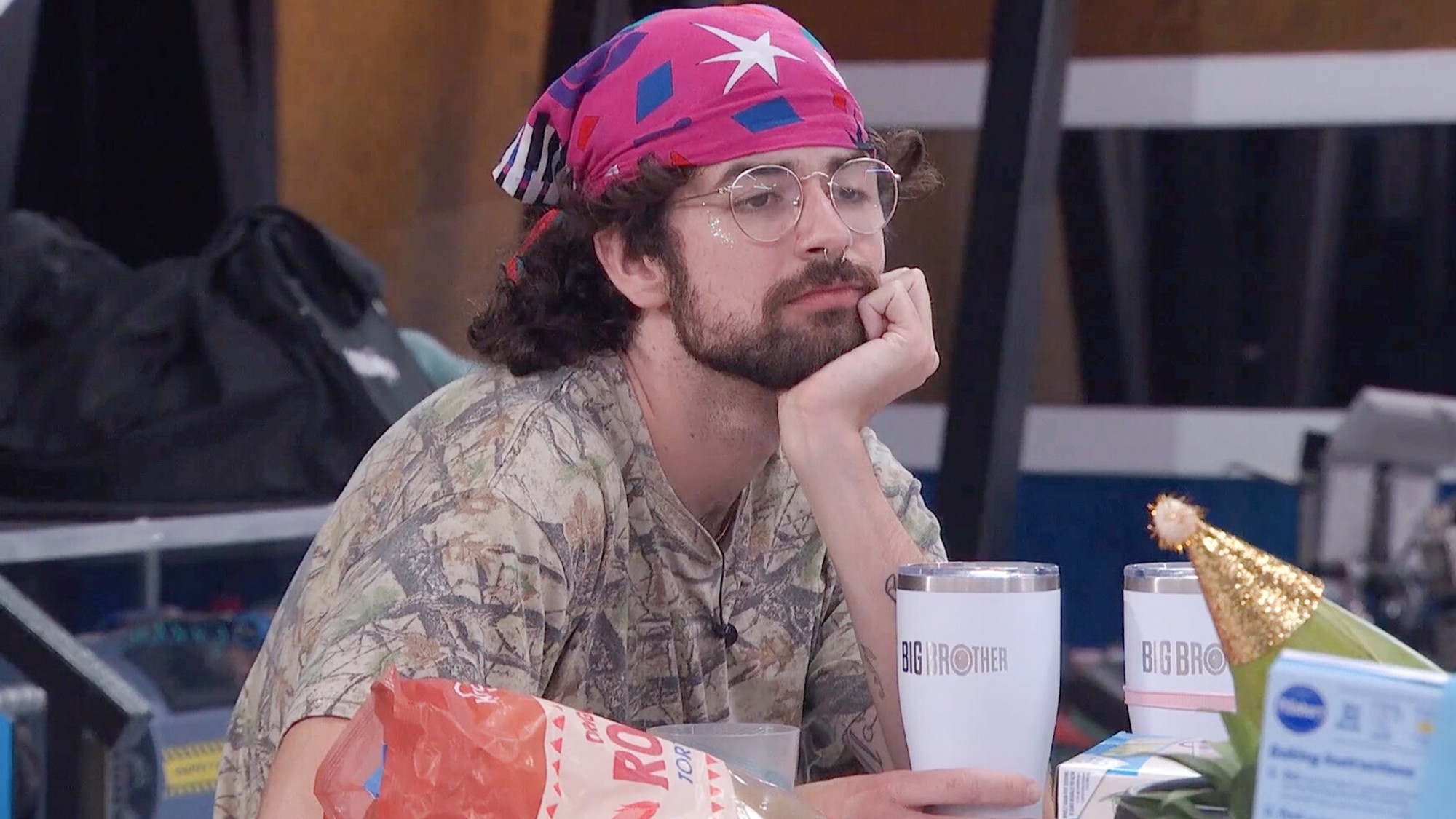 Barrett sitting with his hand under his chin, looking bored. 
