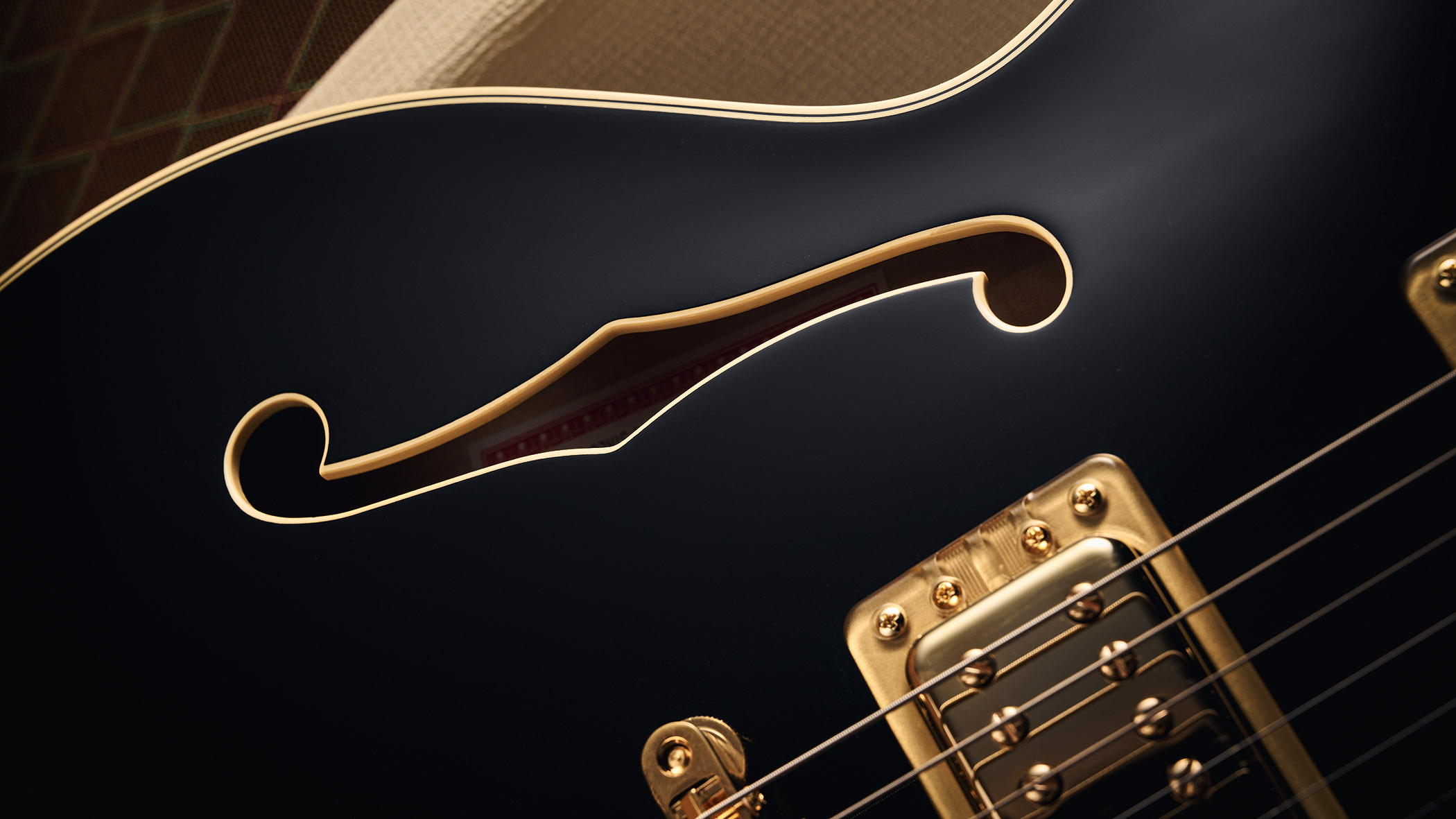 Gretsch Professional Collection Broadkaster LX Center Block: the handsome semi-hollow is finished in black with gold hardware and here is photographed in close-up.