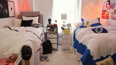 Two dorm beds with neon wall signs