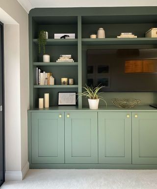 A green built in unit with white ceiling and off white walls