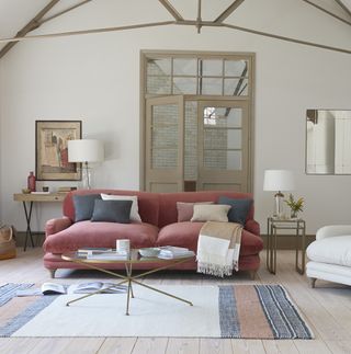 neutral barn conversion living room with muted red sofa