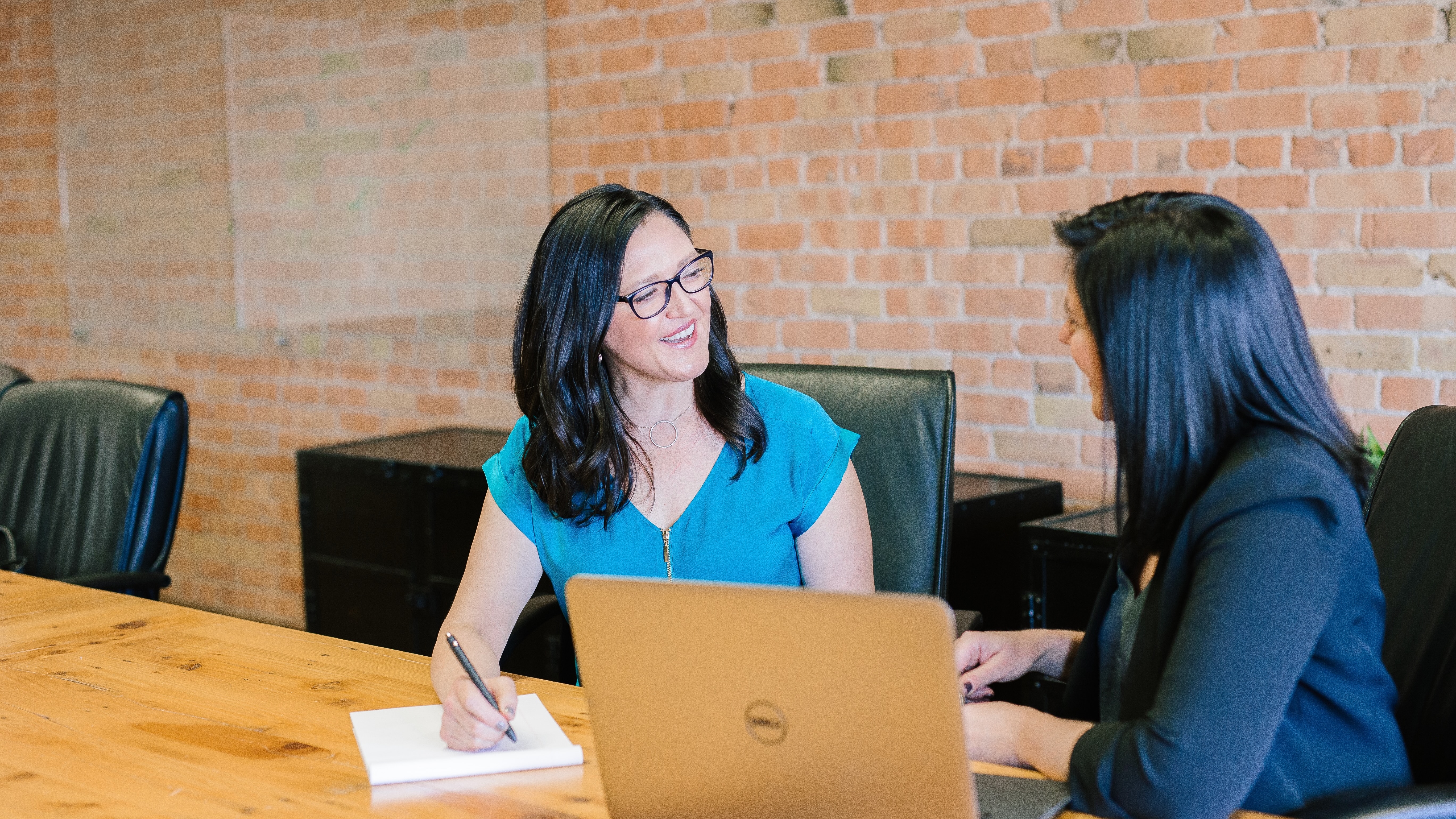 two woman next to a computer in a work environment