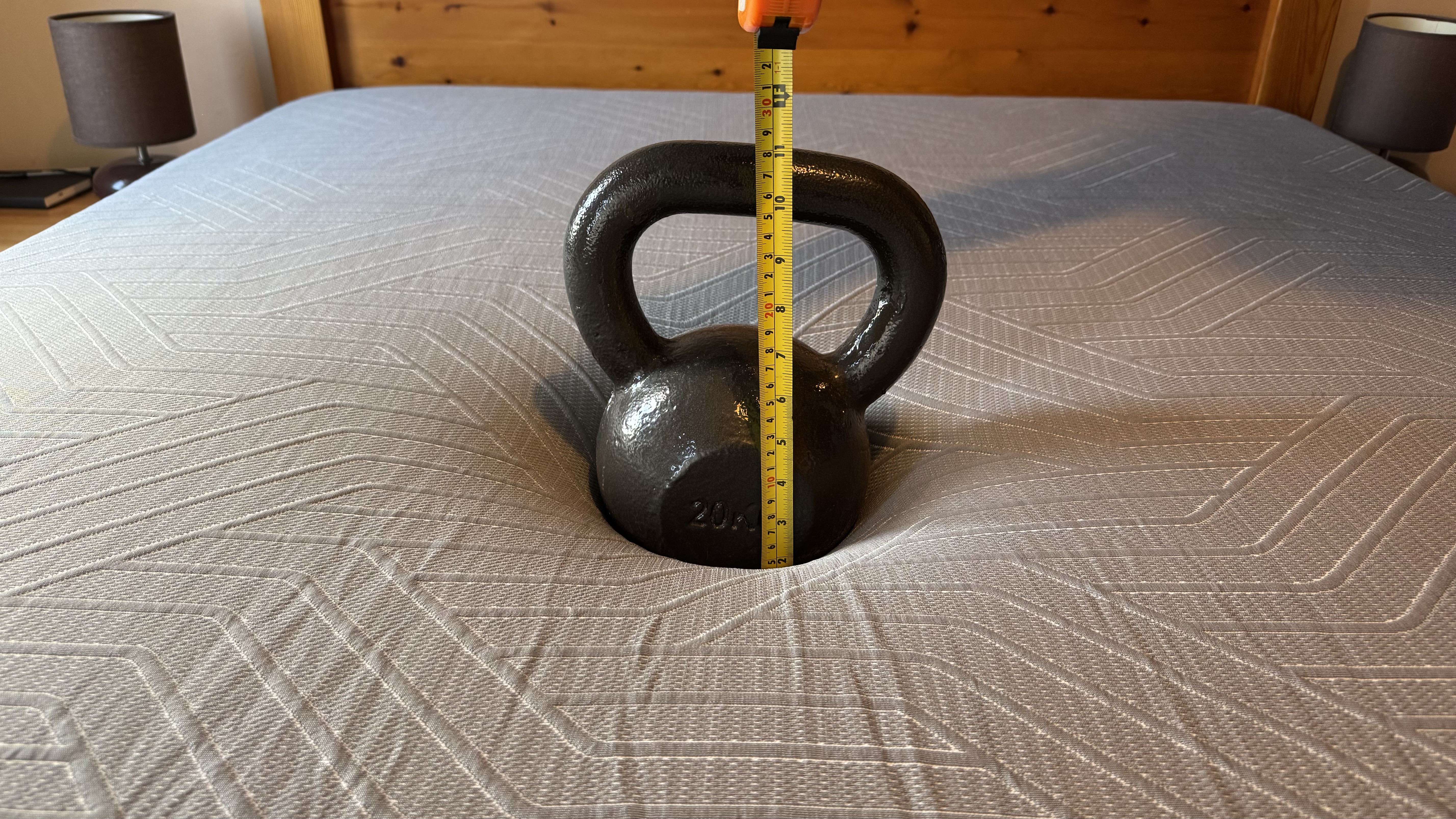 A heavy weight with a tape measure showing sinkage on the EGOHOME Hybrid mattress