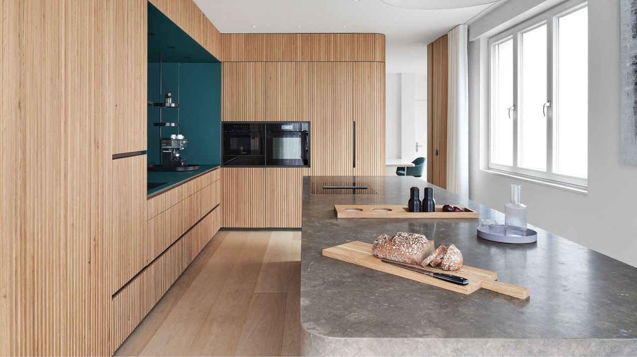 minimalist kitchen with wood cabinets and thick dark marble island