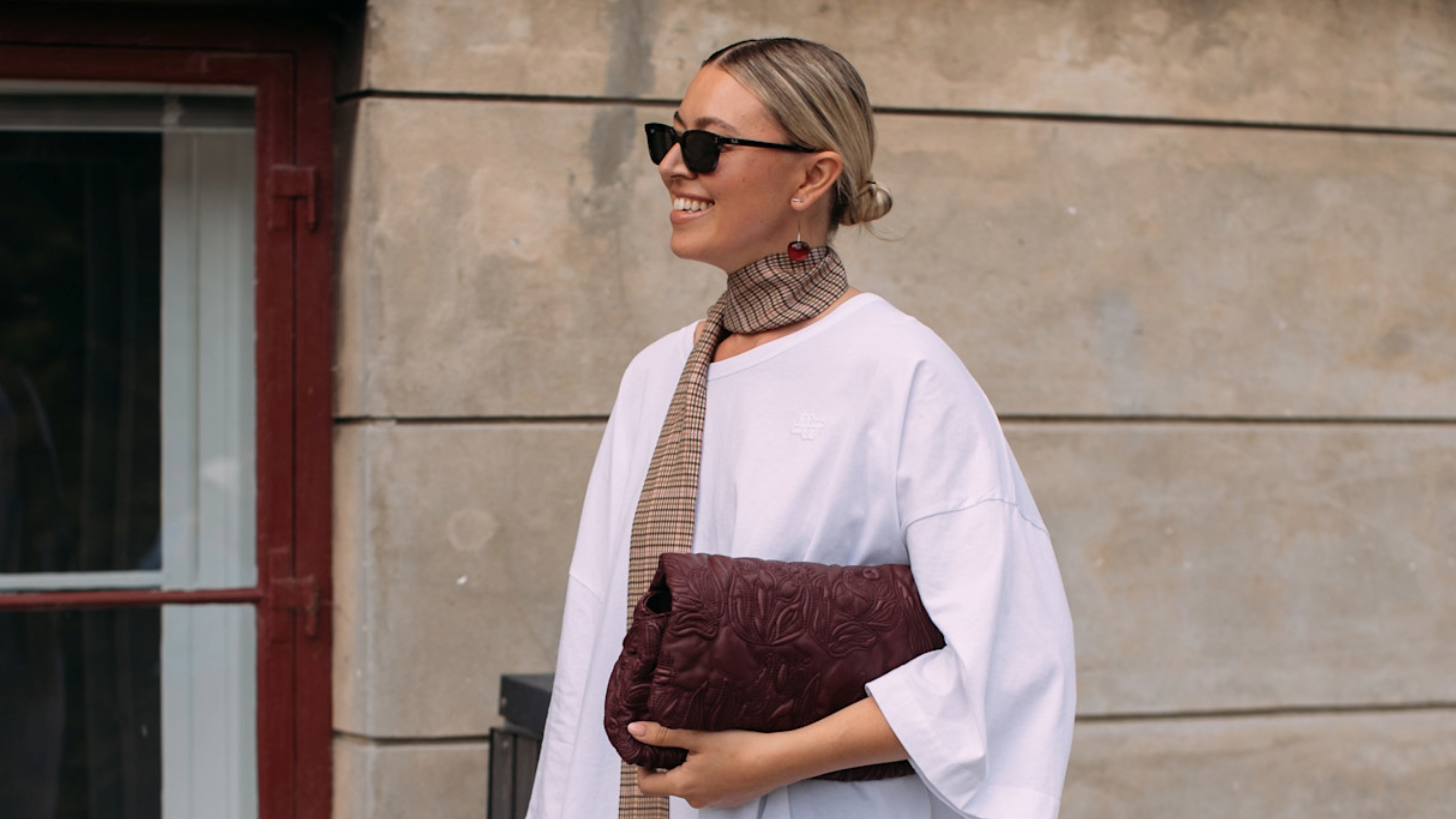 woman wearing a white t-shirt and a pair of sunglasses 