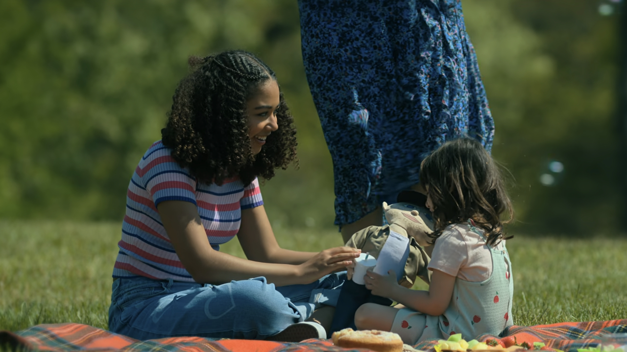 Claire and Coco play with a doll that looks like Steve Blackman during a picnic in the park in the Umbrella Academy series finale