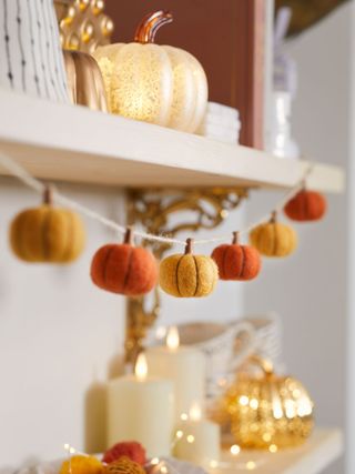 Felt pumpkin garland hanging from mantlepiece