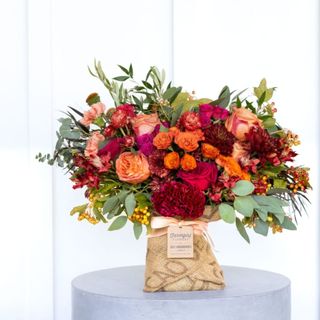 pink orange and red flowers in a burlap bag