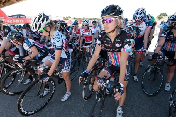 The women's field awaits the start of their mid-day race in the shelter of shade near the start line.