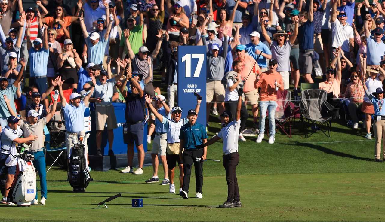 Rai celebrates his ace at the par 3 17th whilst the fans watch from around the green