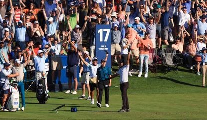 Rai celebrates his ace at the par 3 17th whilst the fans watch from around the green