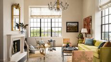 living room with cream walls and fireplace with gold sofa and chandelier