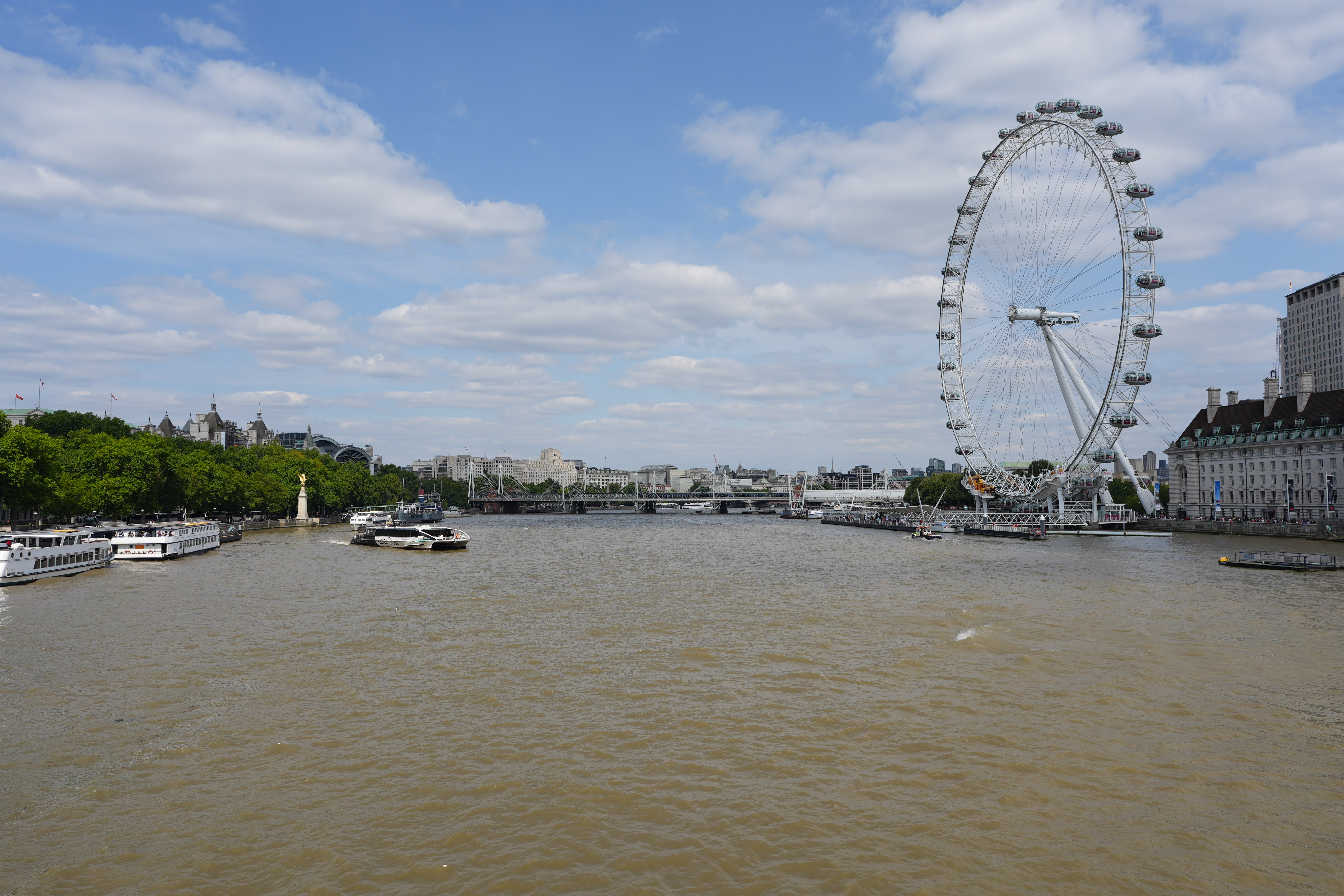 The river Thames with the London eye and a blue cloudy sky