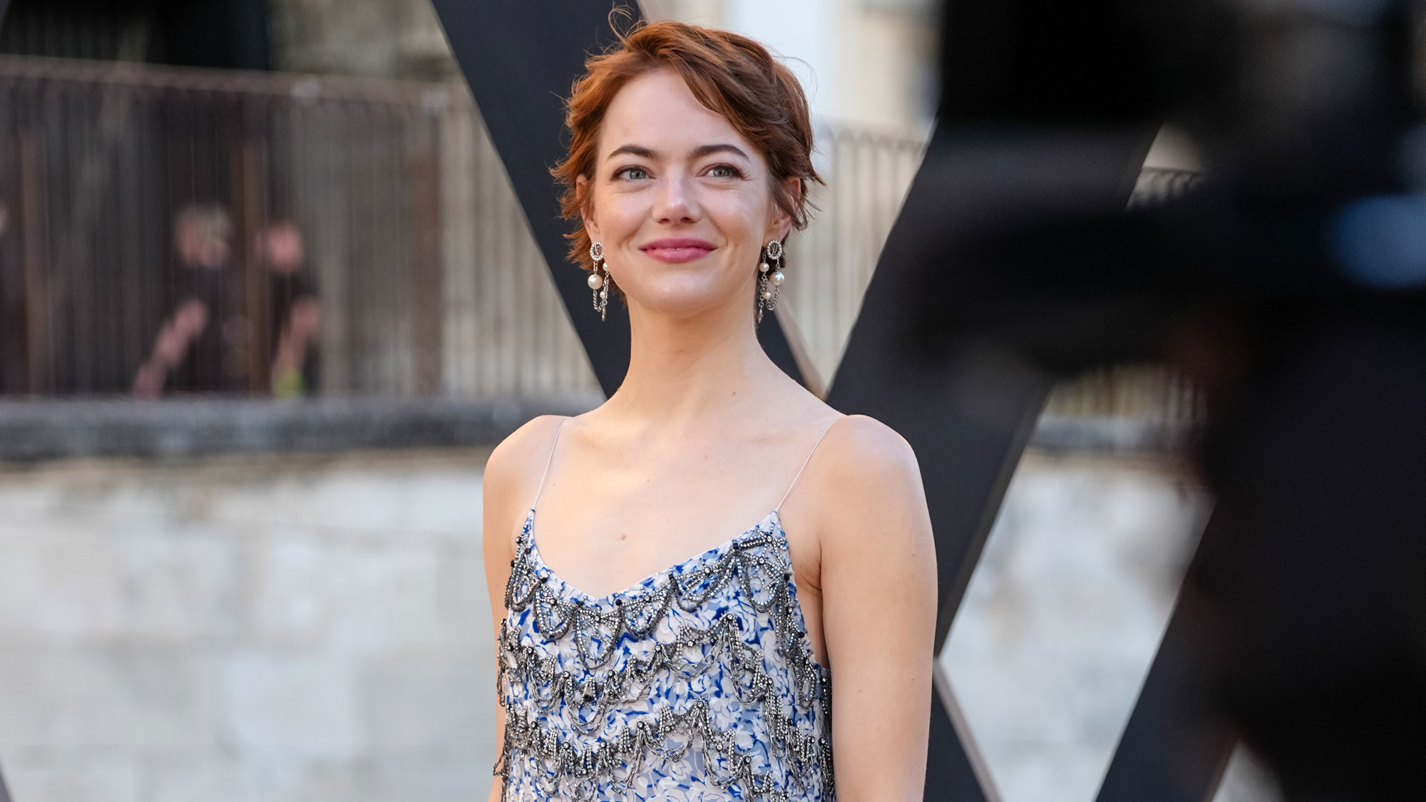 Emma Stone wears a sleeveless dress