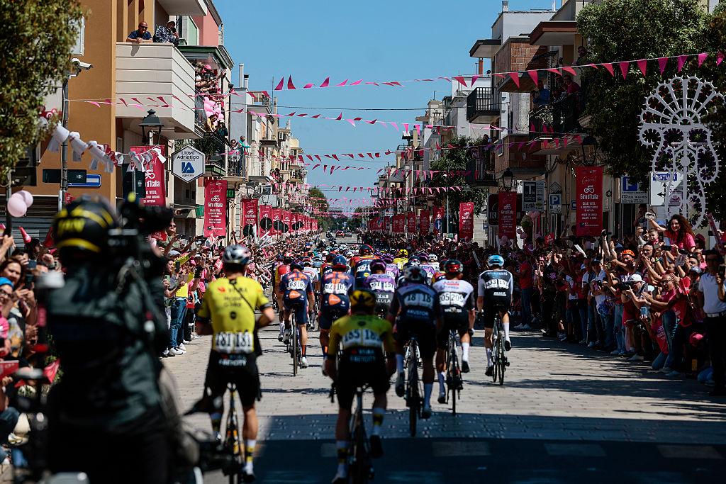 The pack rides through the village of Pezze di Greco during the 4th stage of the 108th Giro d'Italia cycling race 189kms from Alberobello to Lecce on May 13, 2025. (Photo by Luca Bettini / AFP)