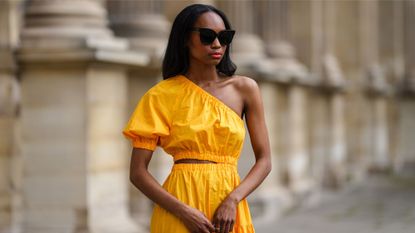 woman wearing yellow dress and sunglasses - winter sun outfit ideas 1322673136