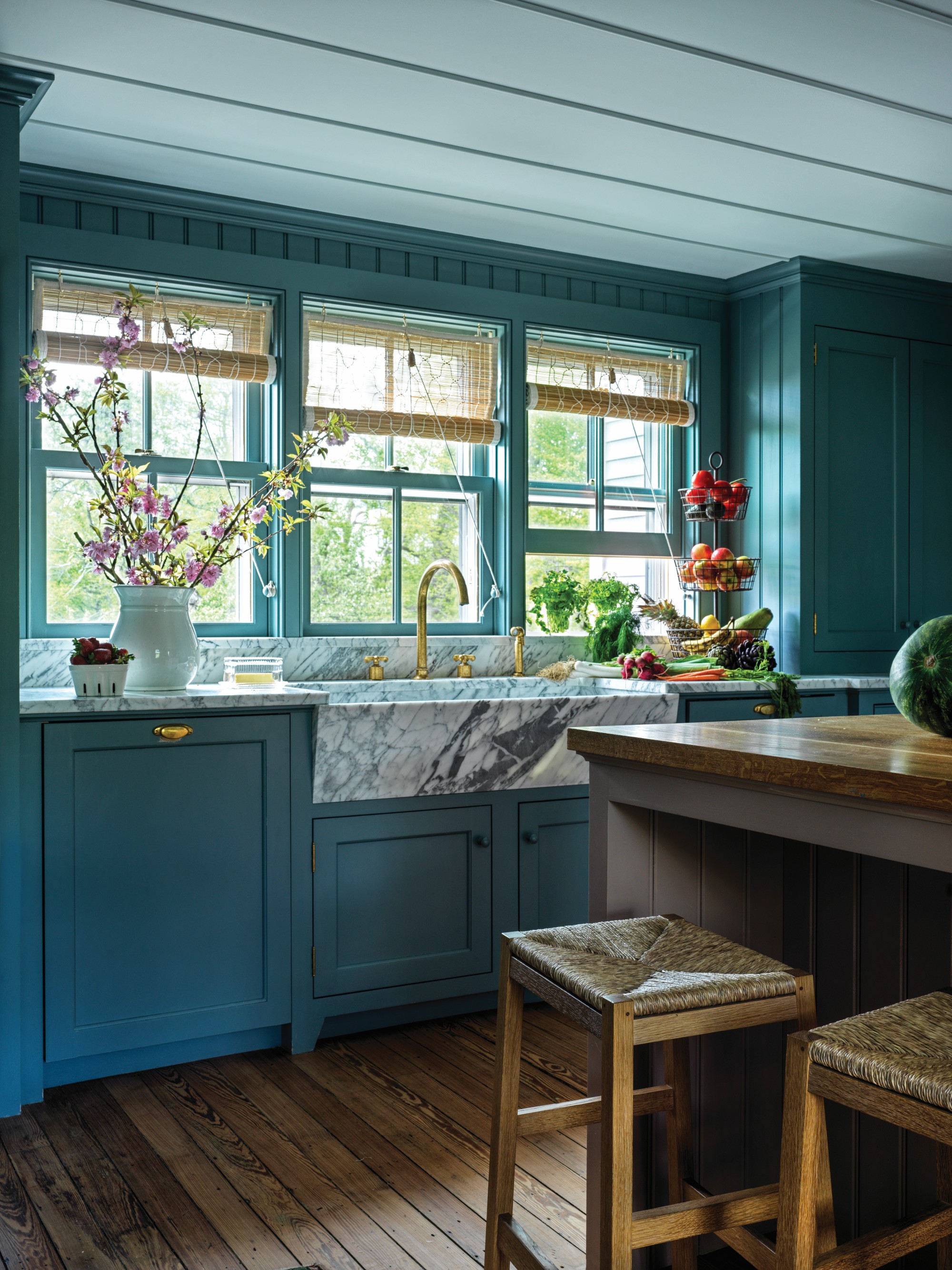 smoky blue country kitchen with a marble sink and wooden island. the ceiling is slatted wood, painted white
