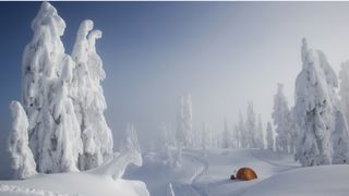 how to go winter camping: tent in extremely wintery scene