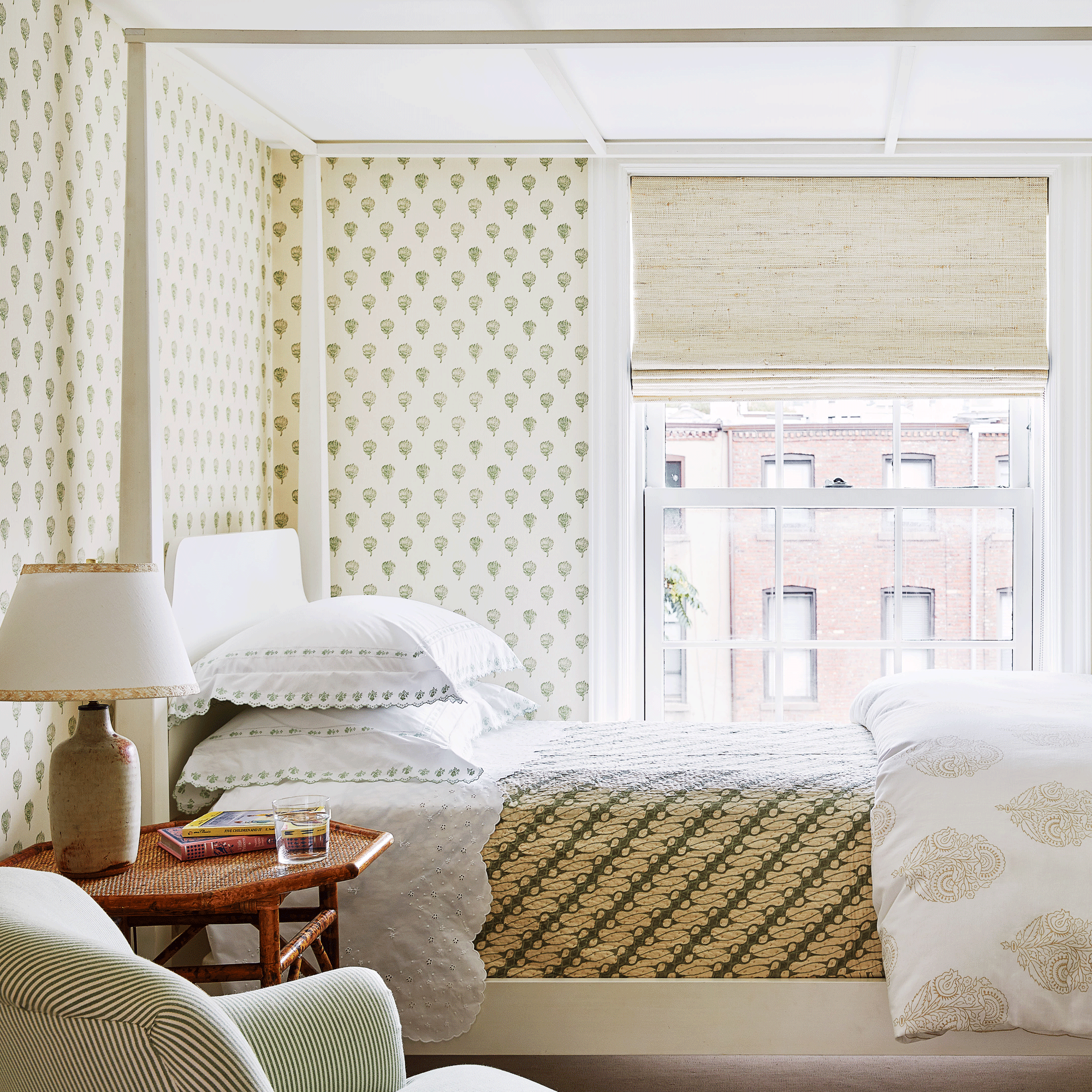 small bedroom with cream and green patterned wallpaper and furnishings throughout