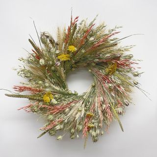 Dried Autumn Grace Wreath against a white wall.