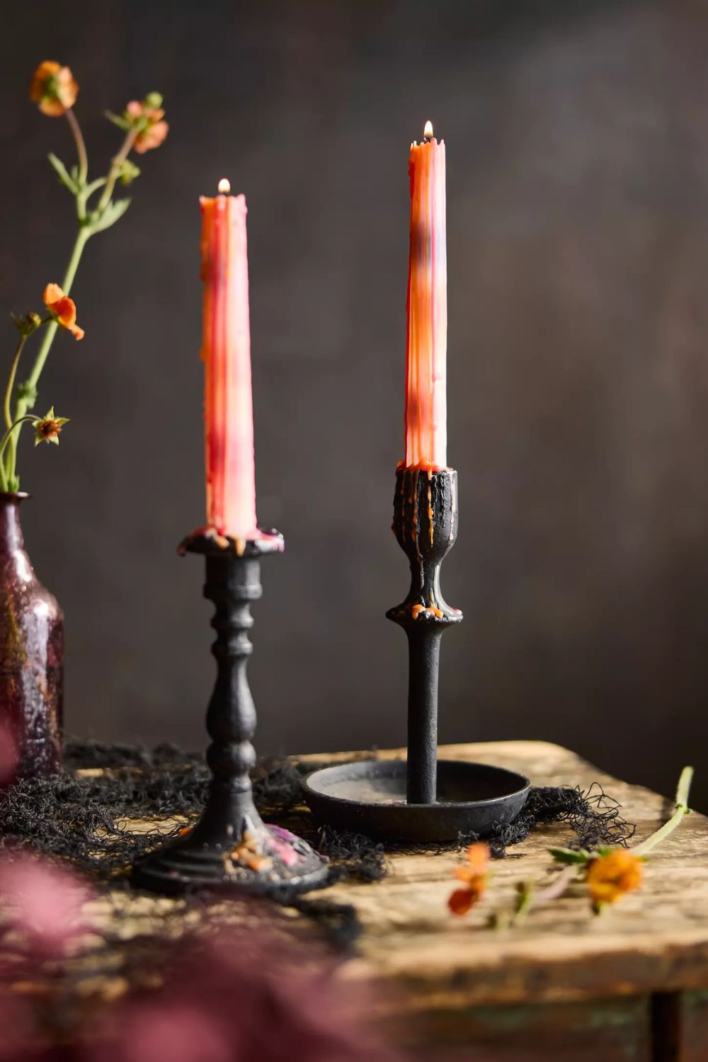 Set of 2 orange glowing taper candles on black metal bases