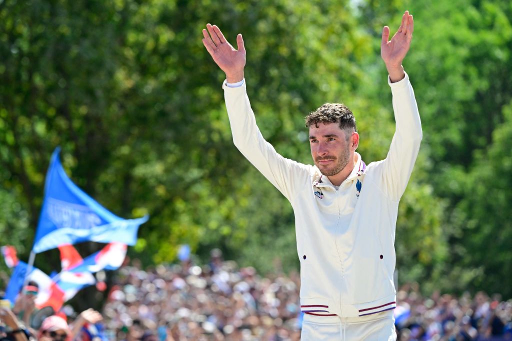 France's Victor Koretzky gestures to spectators as he celebrates his silver medal on the podium after the men's cross-country mountain biking event during the Paris 2024 Olympic Games in Elancourt Hill venue in Elancourt, on July 29, 2024. (Photo by John MACDOUGALL / AFP)