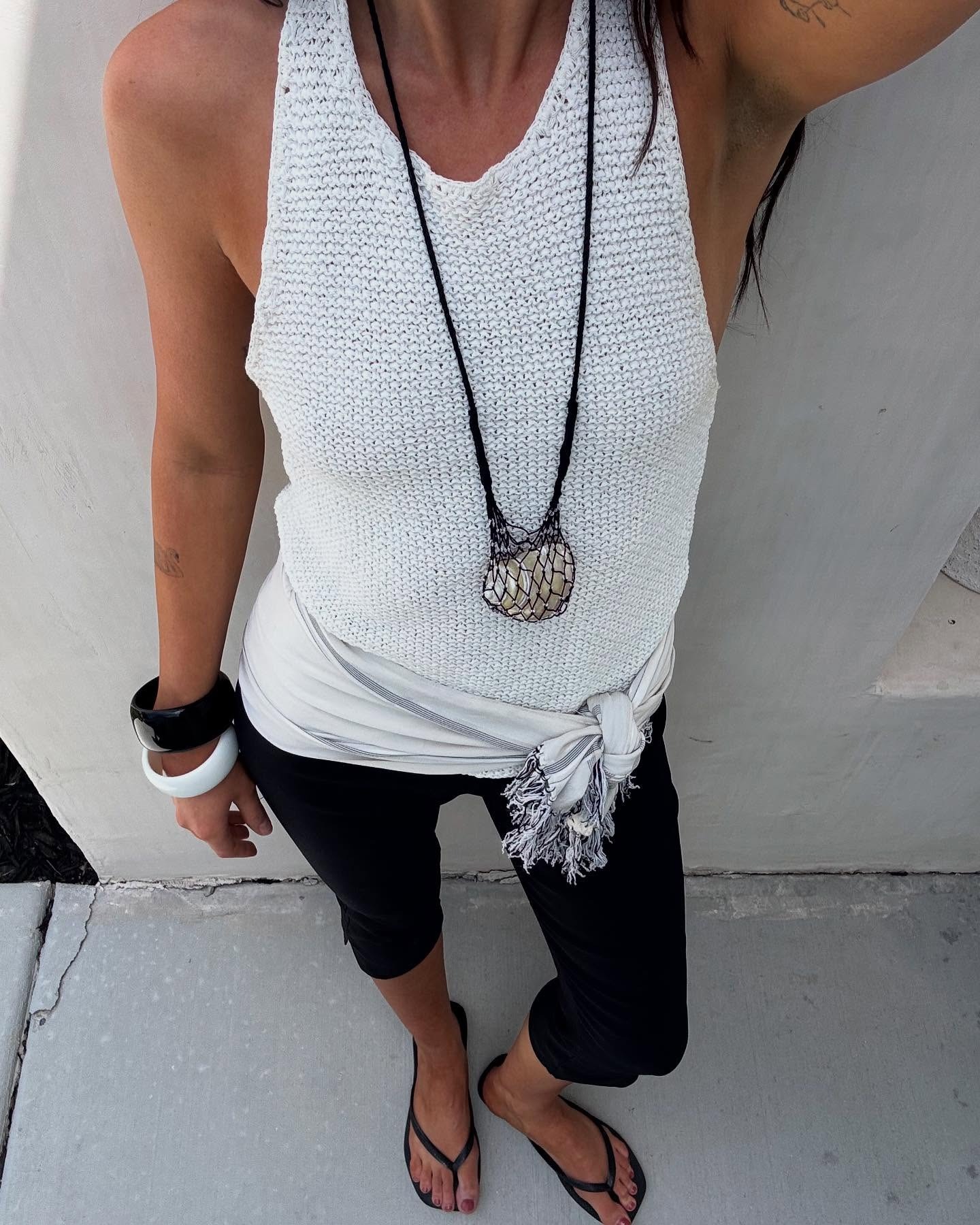 Makenna wears a knit tank top, black capris, and black flip-flops.