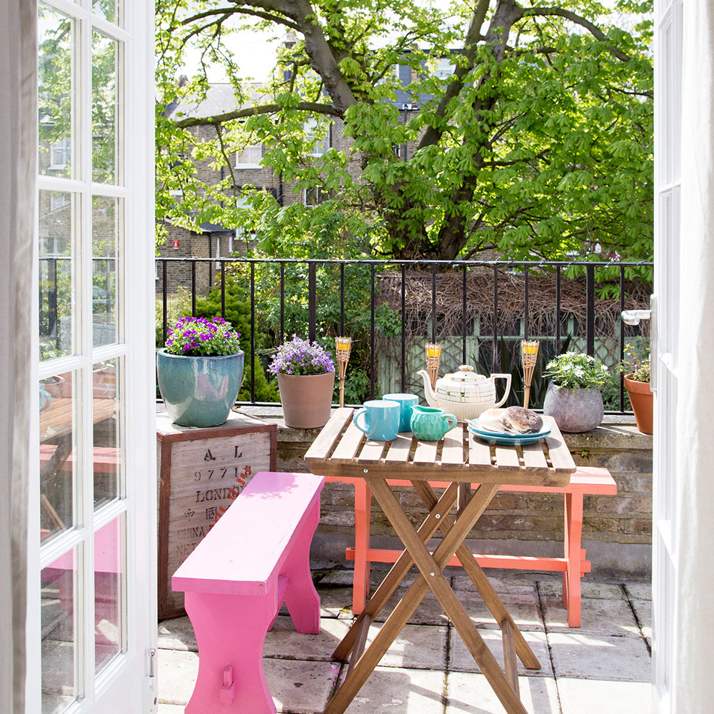 balcony with wooden table and brightly painted benches