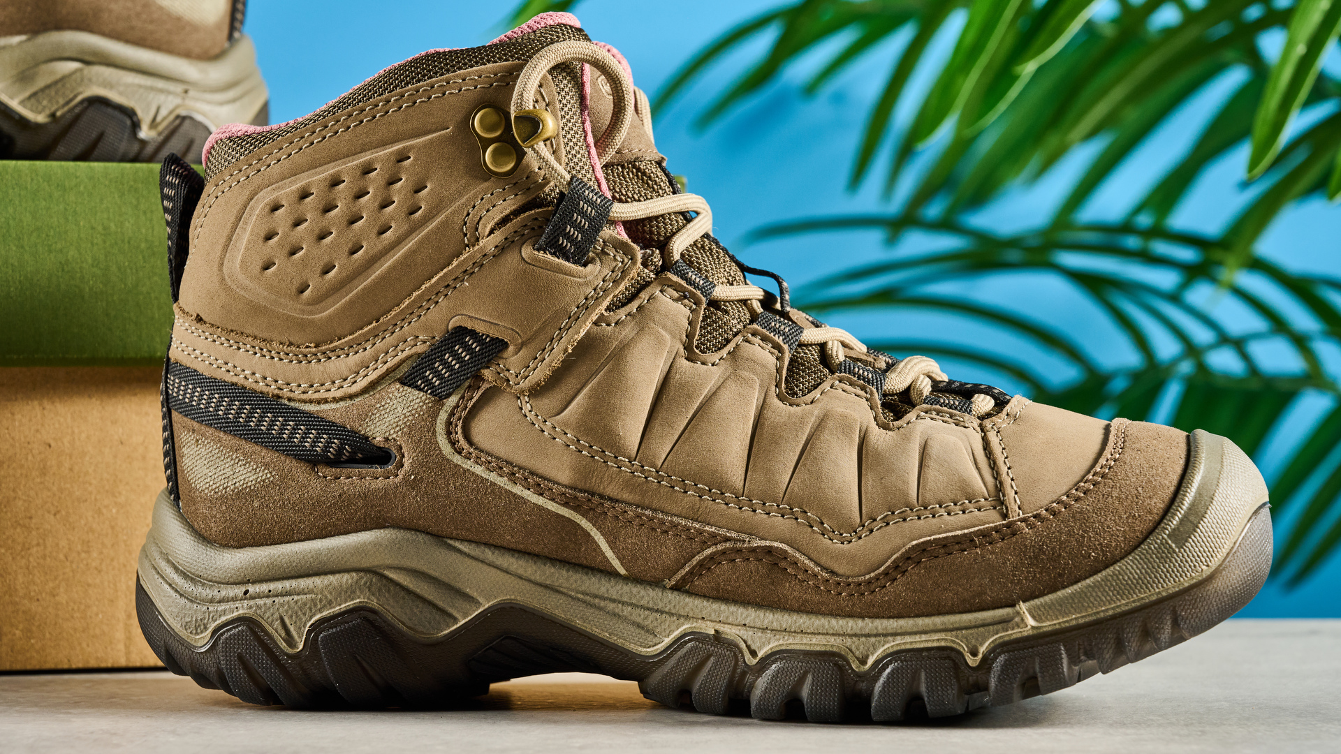 Keen Targhee IV hiking boots photographed in front of a blue background.