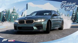 A BMW sedan drifting on an icy road with fake winter wonderland props in the background and a blue, circular border.