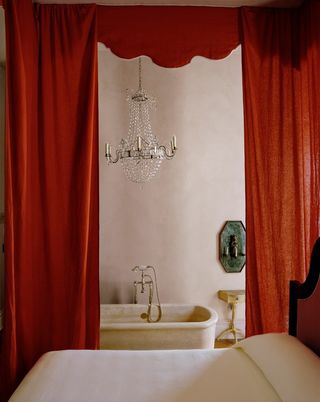 A transitional style hotel features grand decor including glass chandelier and marble bathtubs.