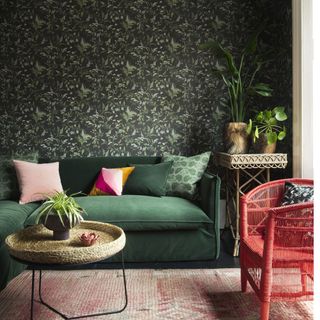 living room with dark wallpaper and green sofa