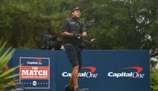 Mickelson hits a driver in front of The Match banners