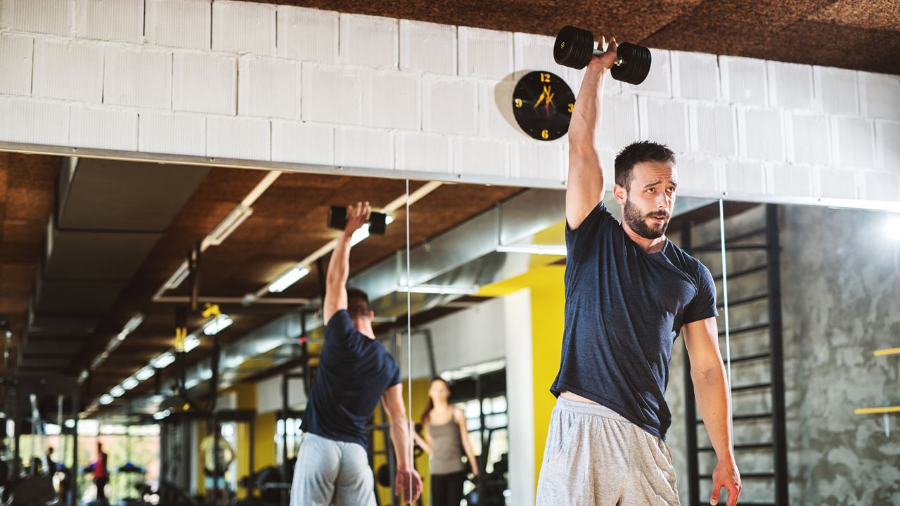 Man performing dumbbell thrusters