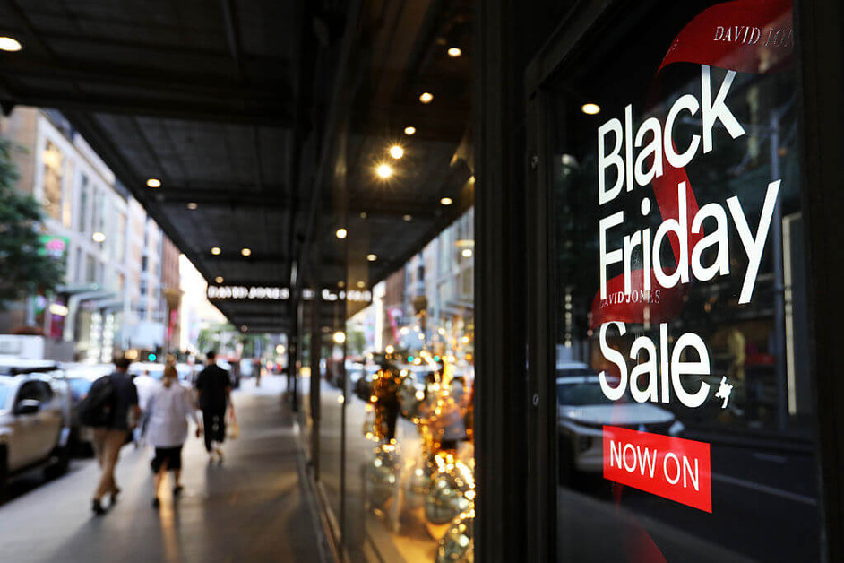 The view of a high street with an illuminated Black Friday advertisement.