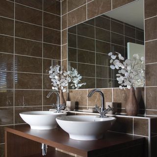 bathroom with washbasin and brown colour tiles wall