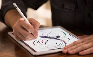 View of a person drawing a colourful bird and lines with an Apple Pencil on an iPad