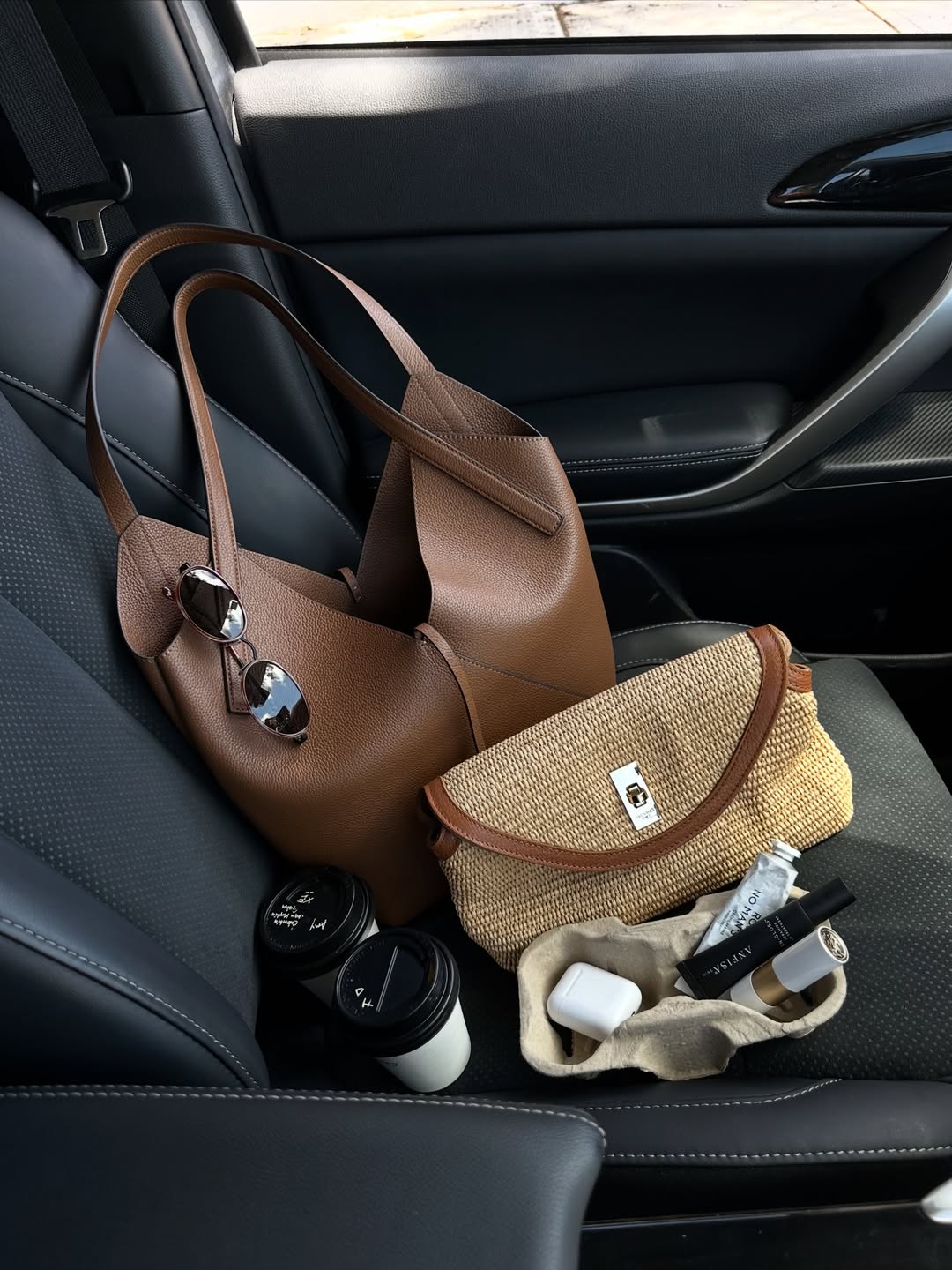 Designer leather and raffia bag in a car seat for luxury spring buys 2026