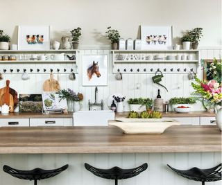 White kitchen, black stools, white shelves and black hooks