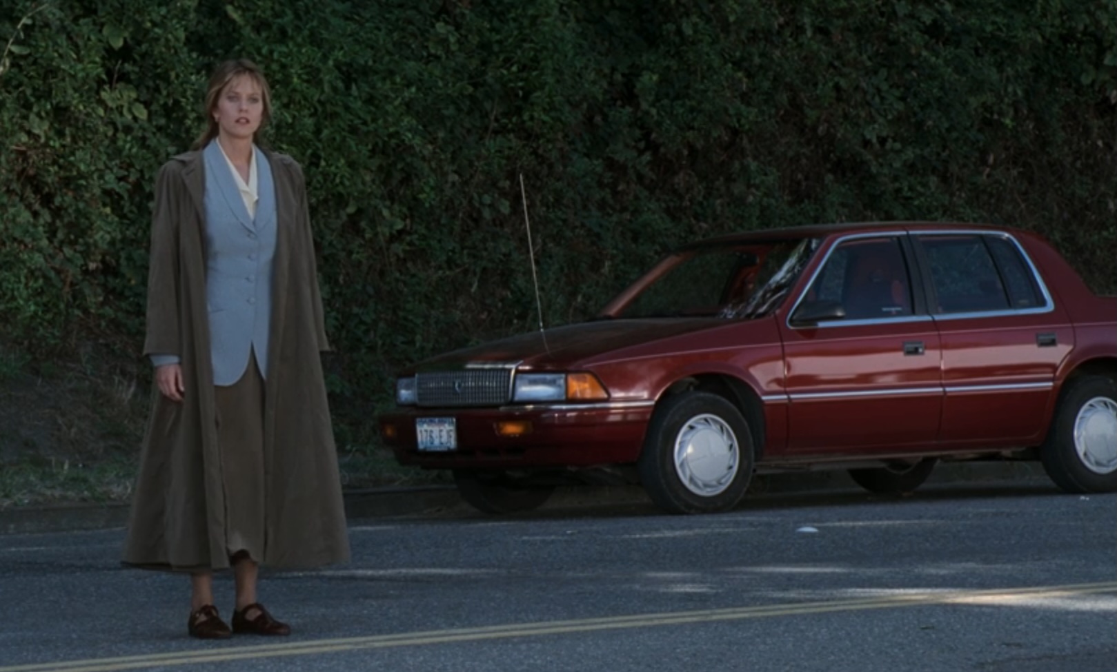 Meg Ryan standing by a red car in Sleepless in Seattle